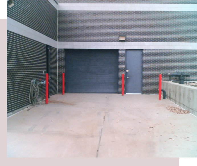 A garage door is open and the walls are painted grey.