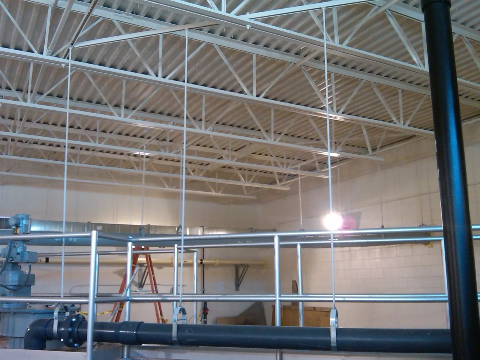 A large room with metal pipes and scaffolding.