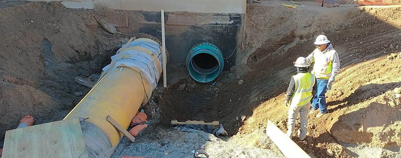 A hole in the ground with a pipe sticking out of it.