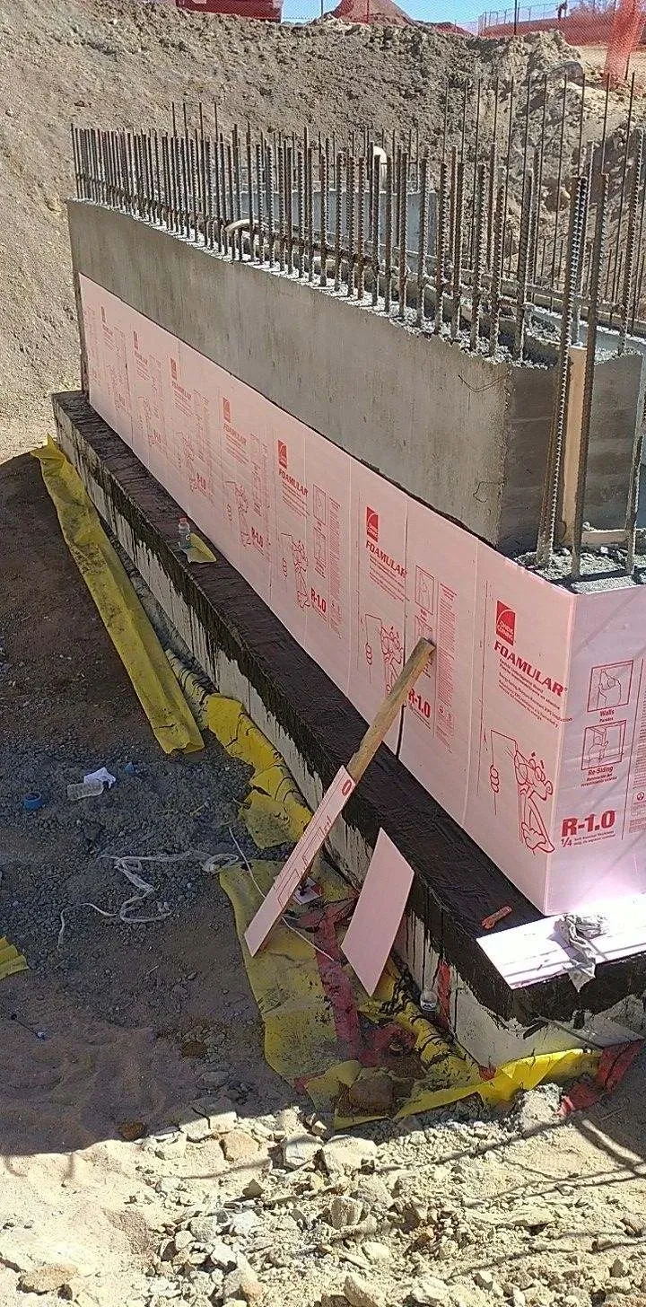 A building with some pink insulation on the side of it