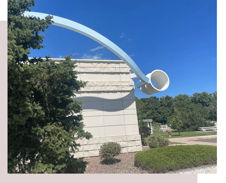 A large white sculpture in the middle of a park.